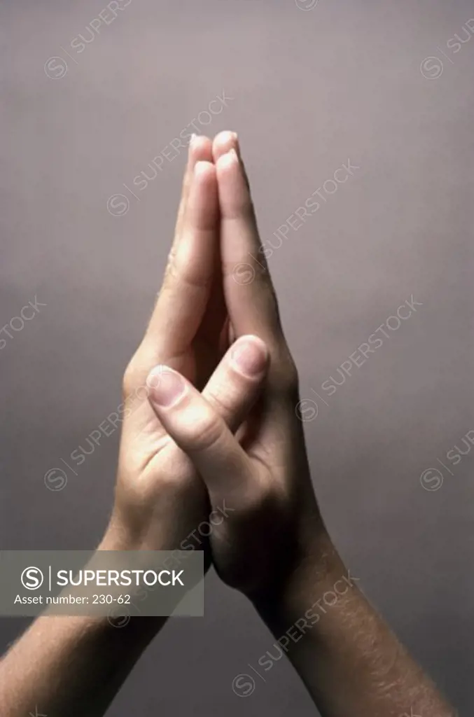 Close-up of a person's hands in the prayer position