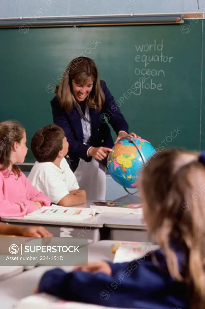 Teacher explaining about a globe in a classroom