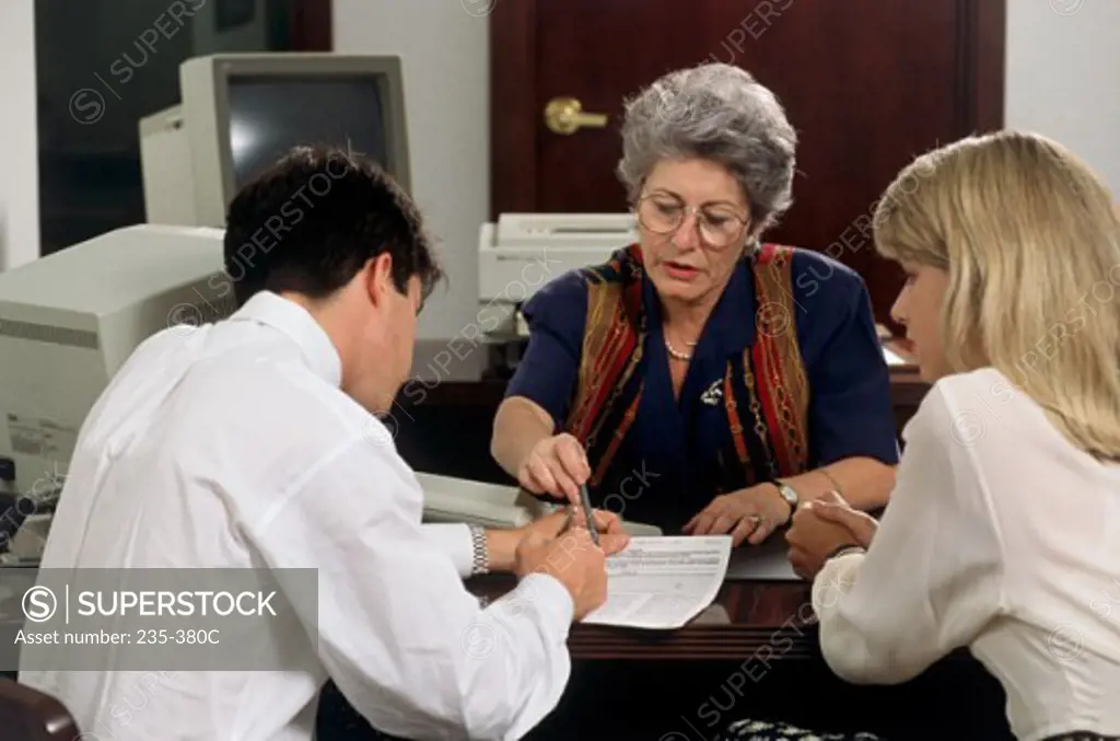 Young couple talking with a financial advisor in a bank