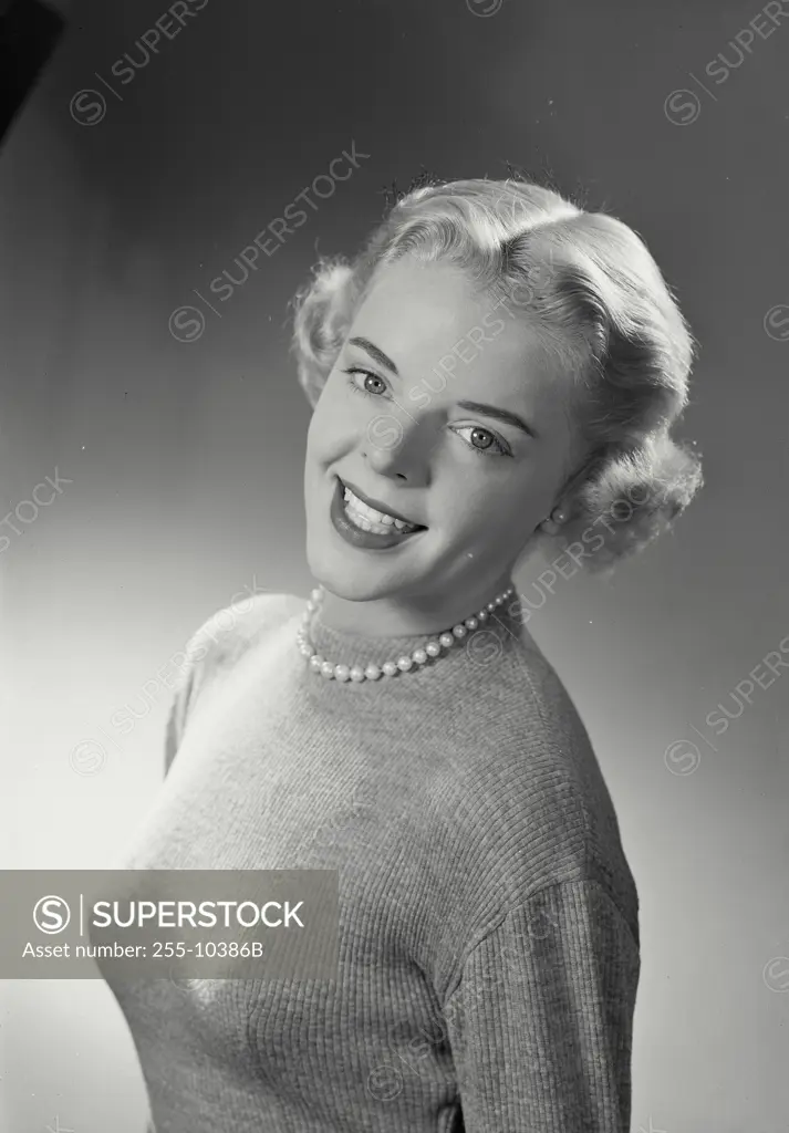 Vintage Photograph. Woman in sweater smiling at camera with head tilted