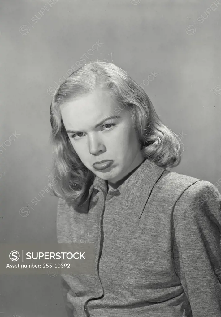 Blonde woman wearing collared blouse with pouty lip expression