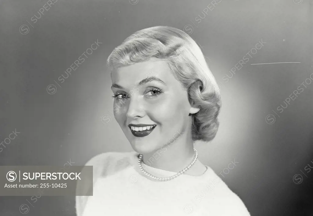 Vintage photograph. Portrait of a young woman in pearl necklace looking at camera