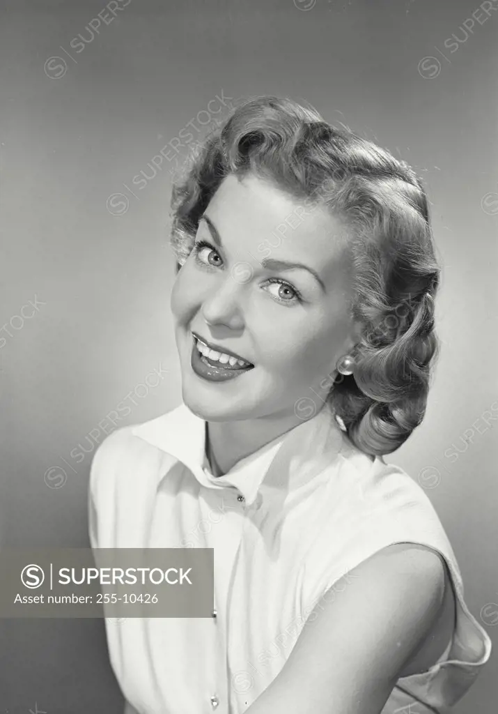Vintage photograph. Portrait of a young woman in sleeveless shirt smiling looking at camera.