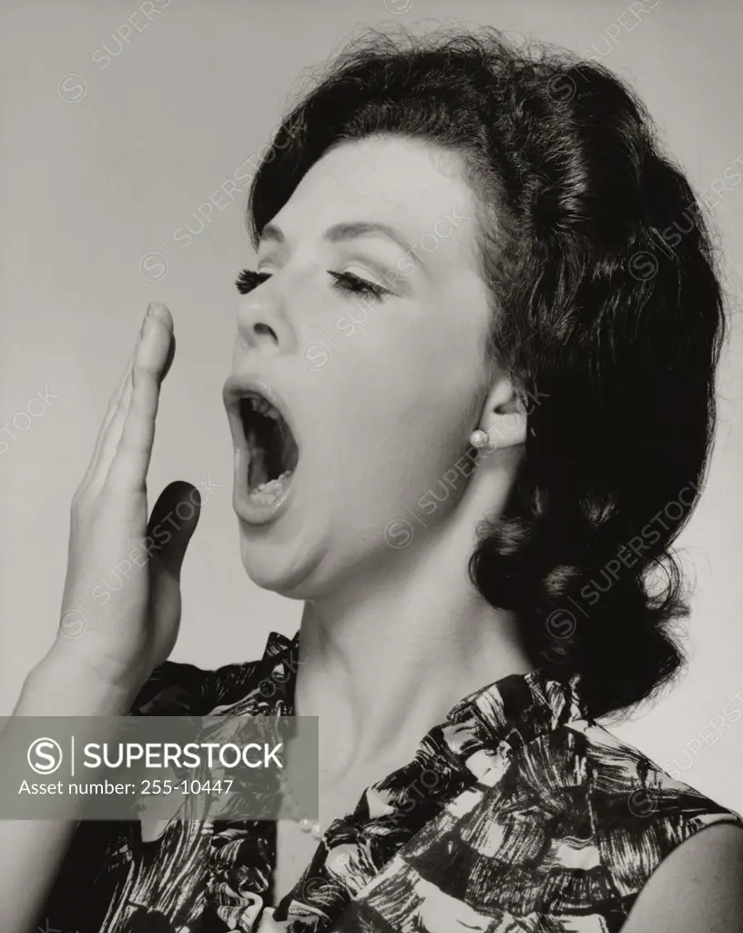 Close-up of a young woman yawning