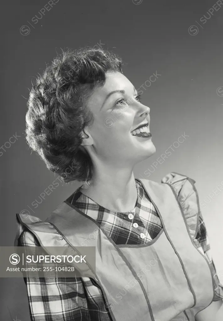 Vintage photograph. Close-up of a young woman in apron smiling