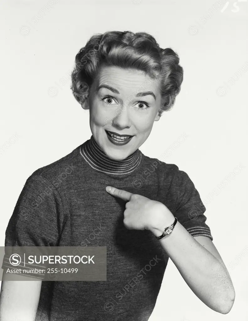 Vintage Photograph. Woman wearing sweater with high striped neck collar pointing finger back at herself