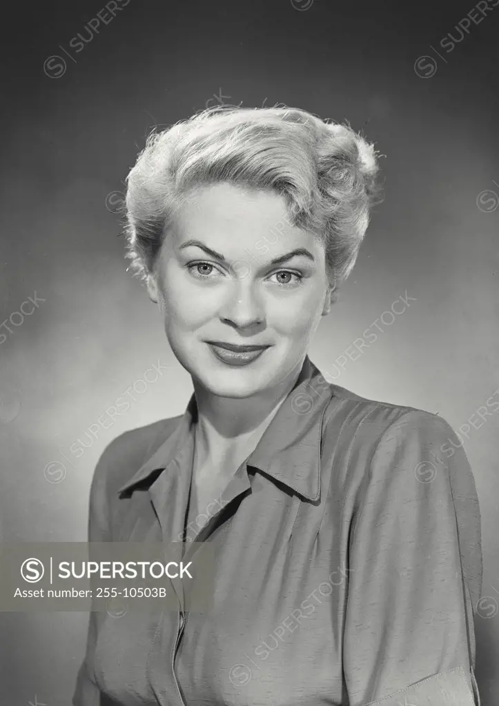 Vintage photograph. Portrait of woman with blonde hair and closed mouth smile