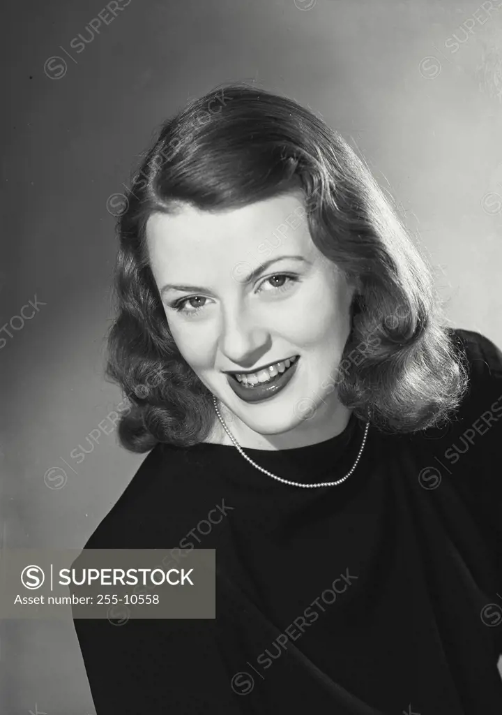Vintage Photograph. Smiling woman wearing black blouse with thin necklace