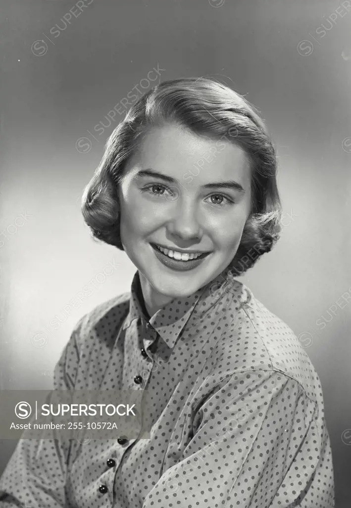 Portrait of young woman smiling wearing polka dotted blouse