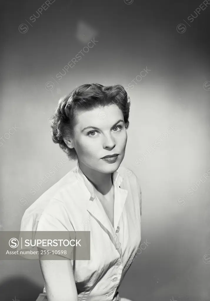 Vintage Photograph. Woman in button blouse looking ahead at camera
