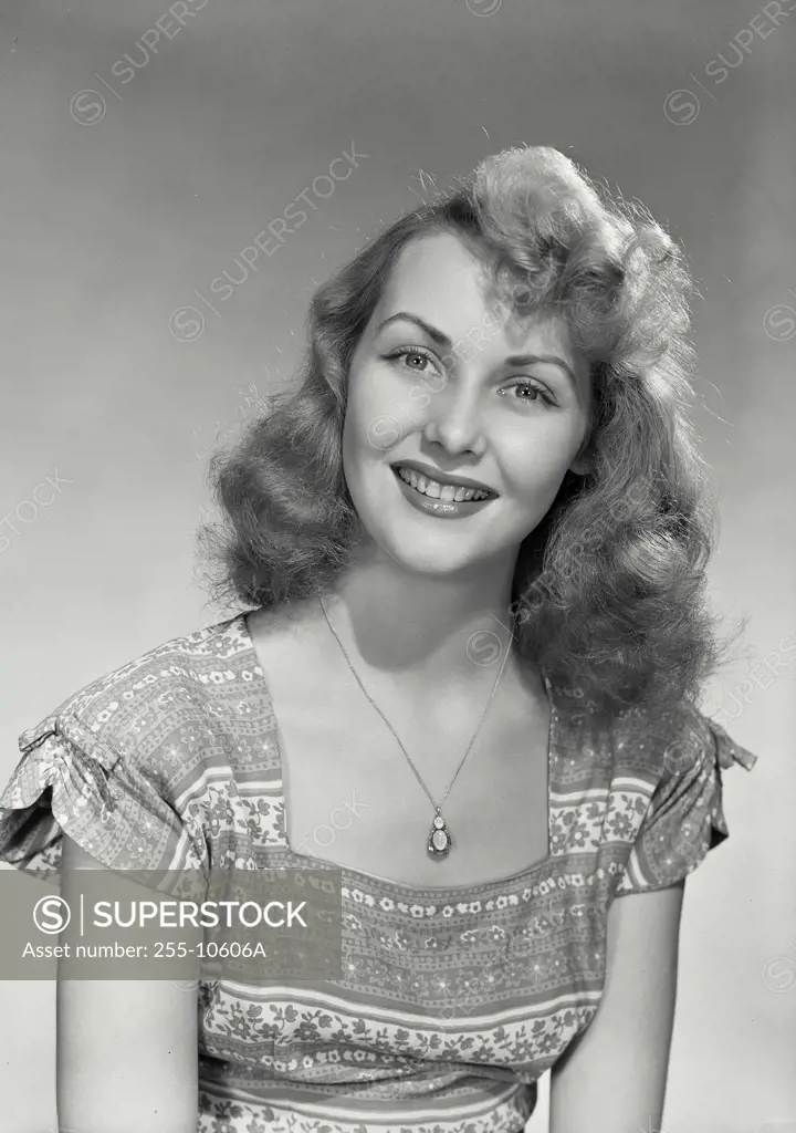 Vintage Photograph. Smiling woman wearing floral patterned blouse and pendant necklace