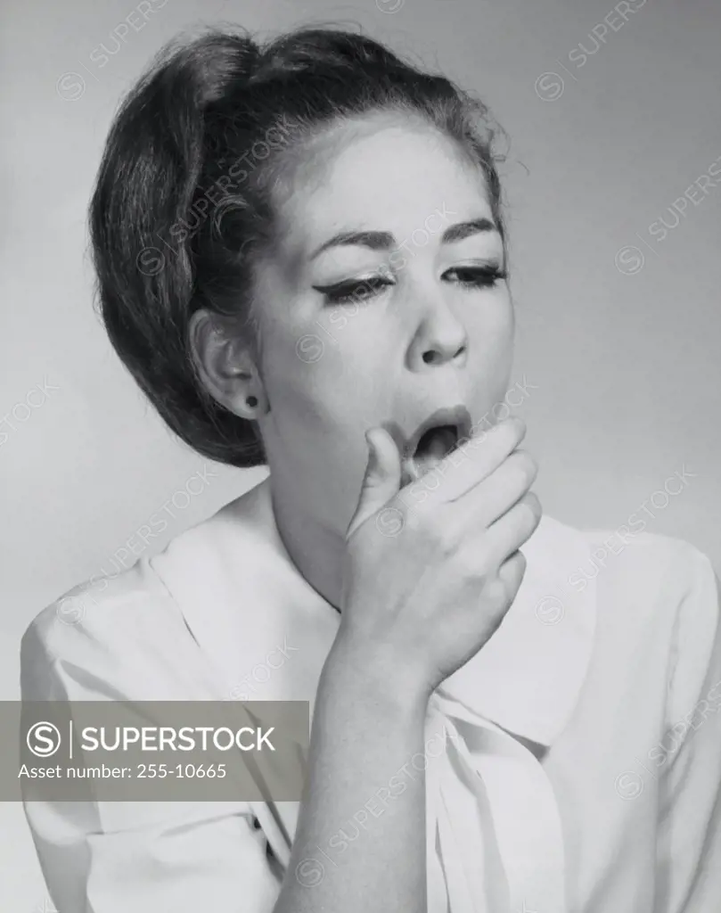 Close-up of a young woman yawning