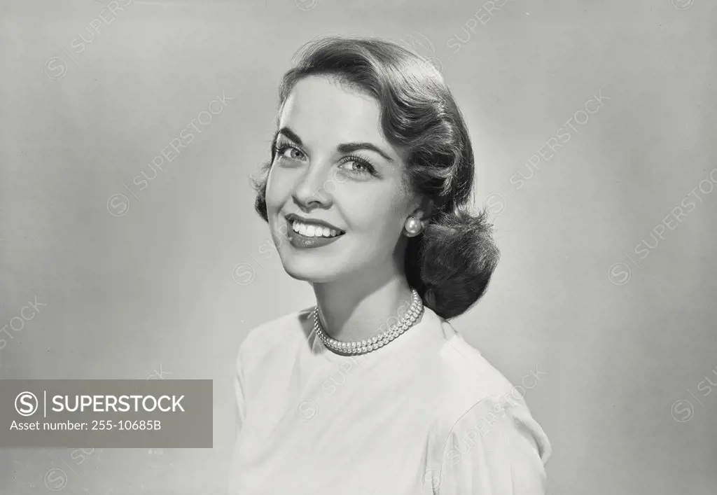 Vintage photograph. Brunette woman turned to side and smiling at camera