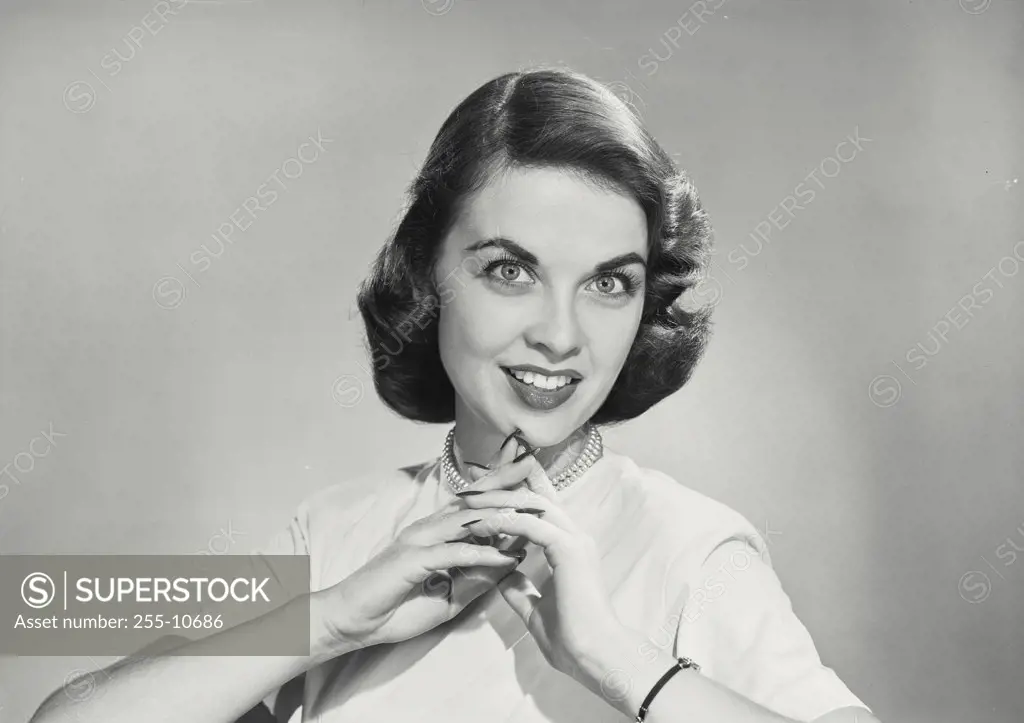 Vintage photograph. Brunette woman with hands clasped in front of chin