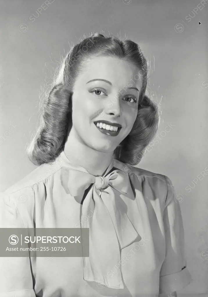 Vintage Photograph. Woman wearing blouse with bow around collar smiling