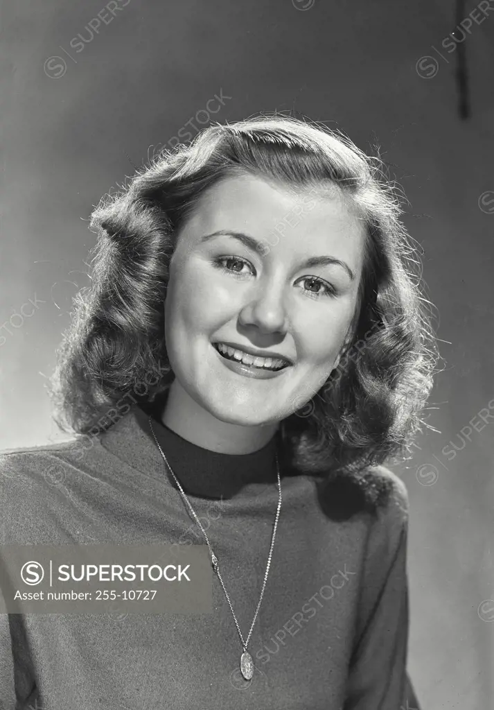 Vintage Photograph. Woman with curled hair wearing sweater top smiling at camera