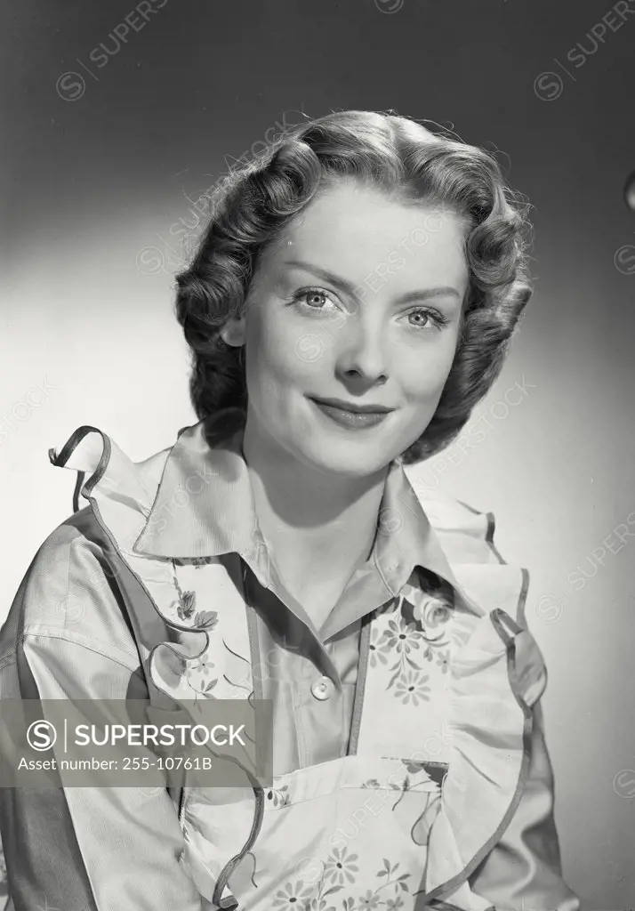 Vintage photograph. Woman in flower apron smiling at camera