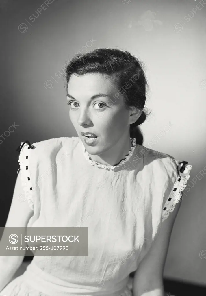 Vintage photograph. Portrait of a young dark haired woman looking surprised