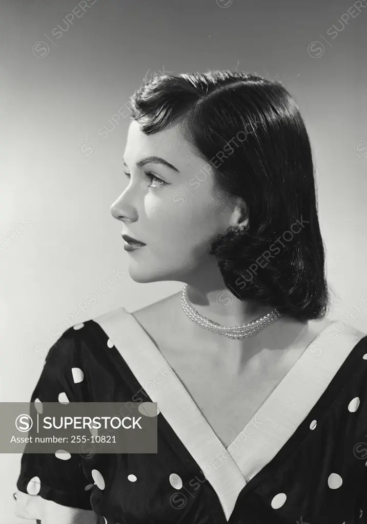 Vintage Photograph. Young brunette woman wearing black blouse with white polka dots turned to side, Frame 2