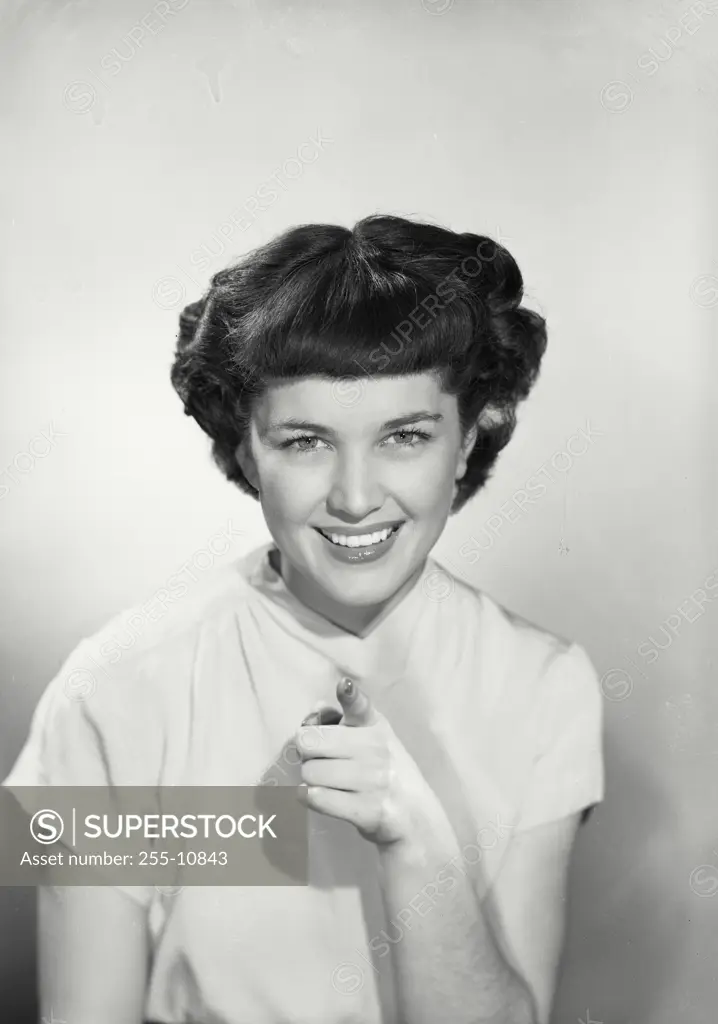 Vintage Photograph. Woman in v-cut blouse smiling and pointing ahead