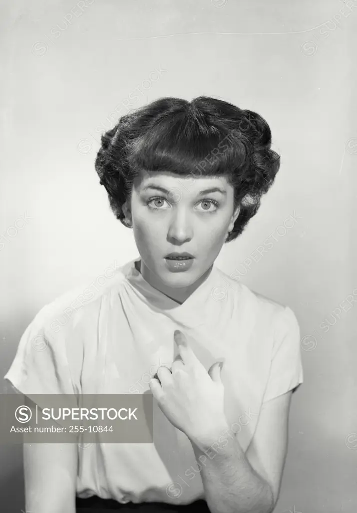 Vintage Photograph. Woman in v-cut blouse pointing at herself with eyebrows raised