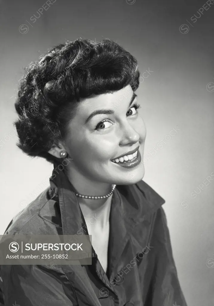 Vintage photograph. Brunette woman with short hair smiling wearing blouse with collar popped up