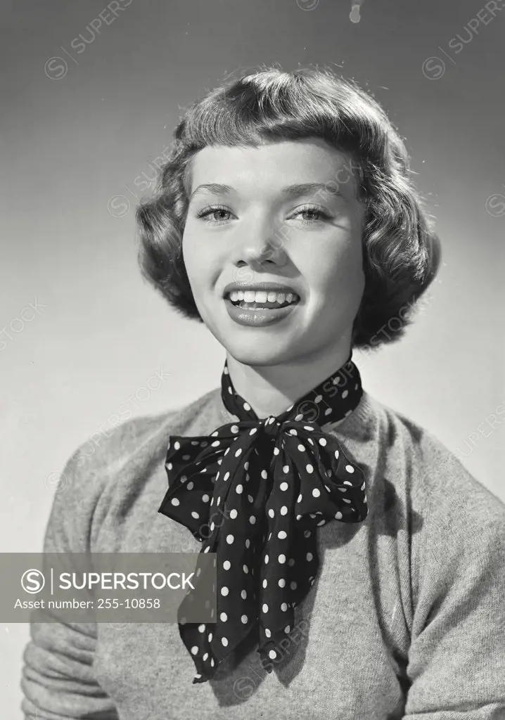 Vintage photograph. Woman with short bangs smiling wearing polka dot silk scarf