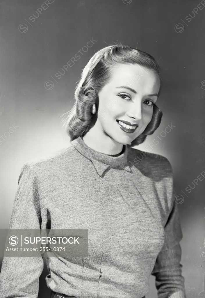 Woman with blonde hair wearing grey sweater smiling