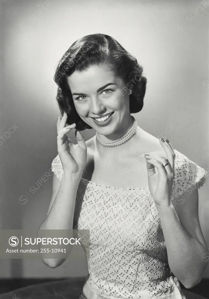 Vintage photograph. Portrait of woman in dress with hands up smiling at camera.
