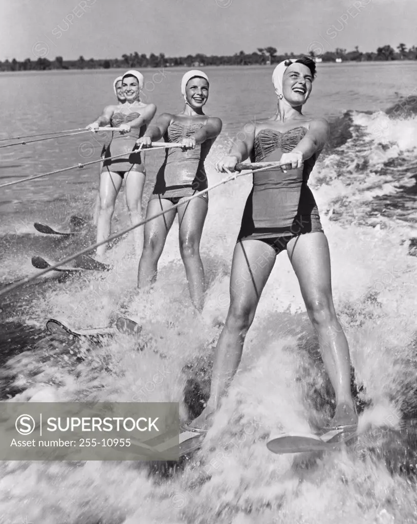 Four young women waterskiing in the sea