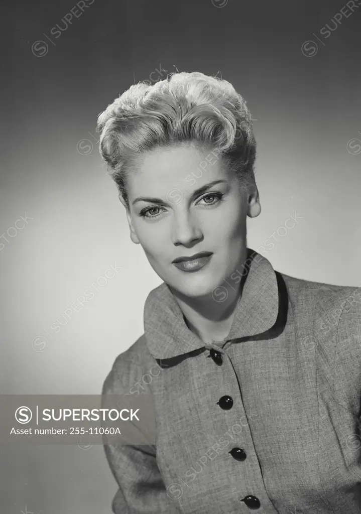 Vintage Photograph. Blonde woman with hair up wearing coat with black buttons