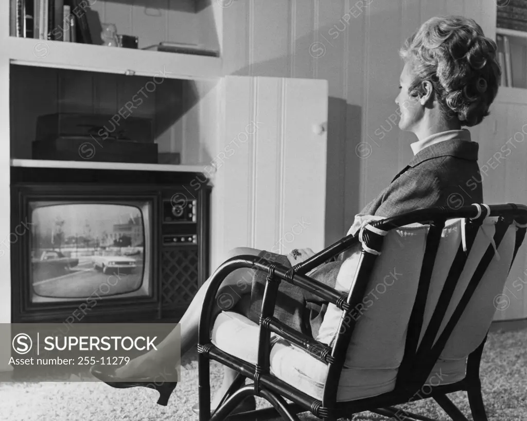 Side profile of a mature woman watching television