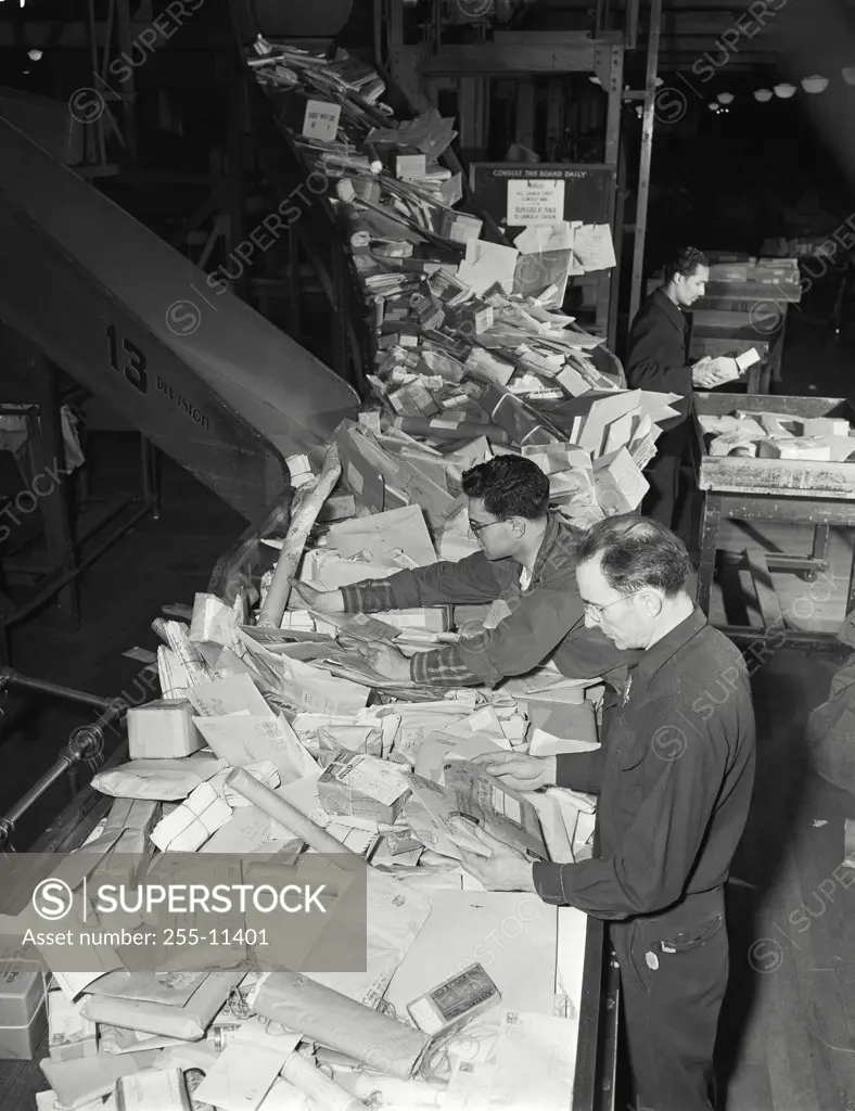 Vintage photograph. High angle view of postal workers sorting mail at the New York General Post Office. Seperation of mails at form table for dispatch