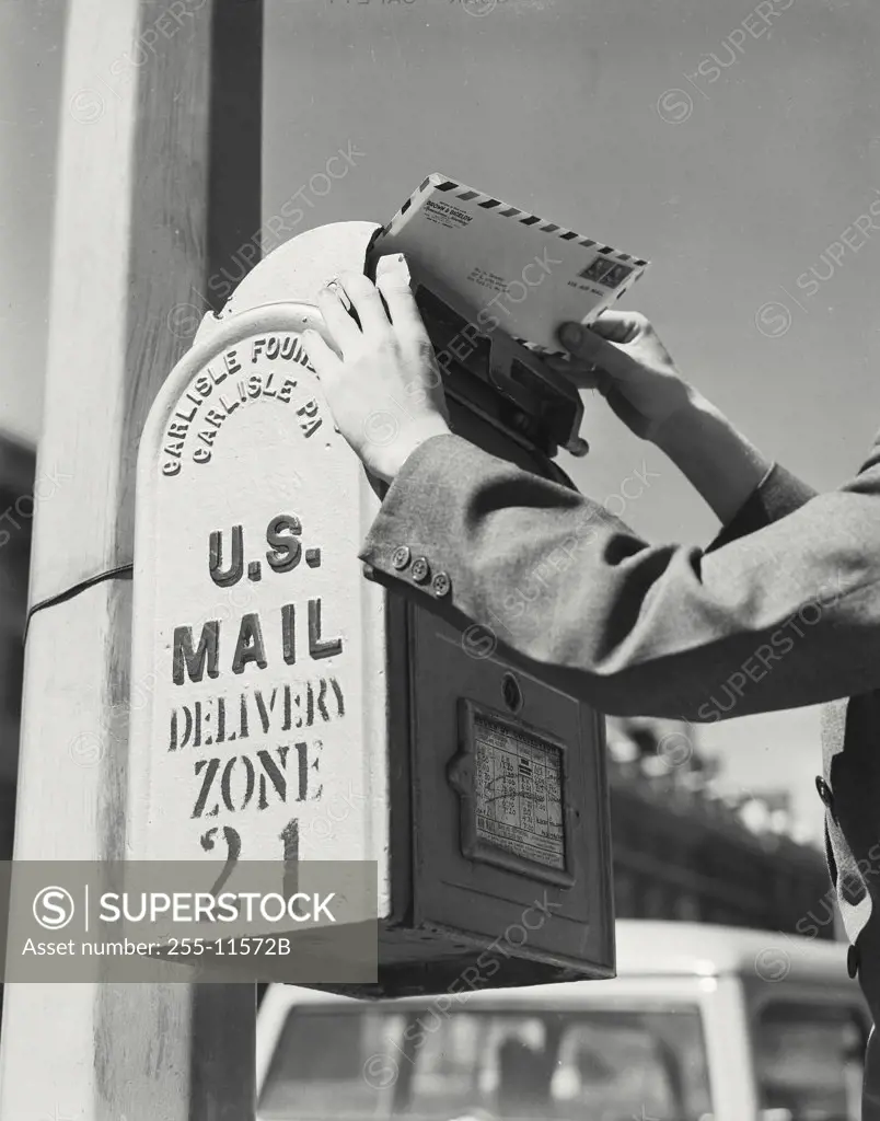 Vintage photograph. Hands placing a letter in US mail box