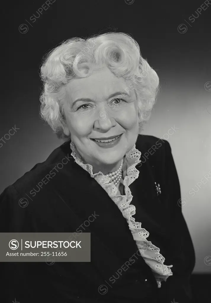 Vintage Photograph. Older woman in coat smiling at camera. Frame 2