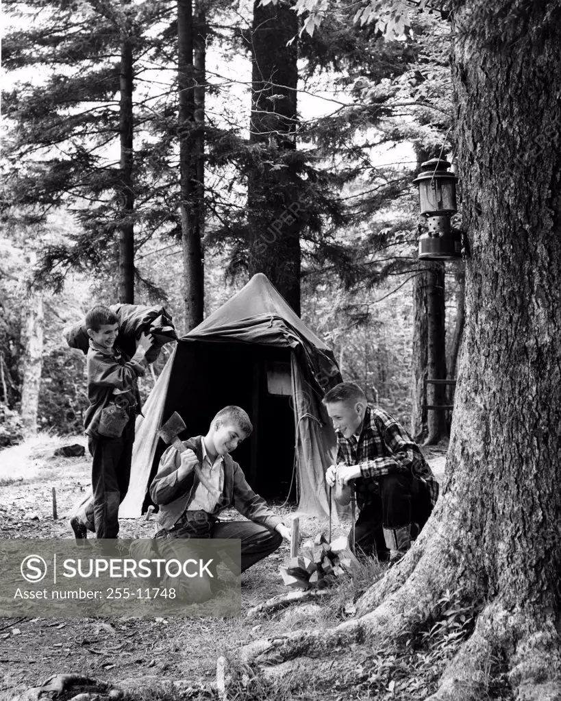Three boys camping in forest