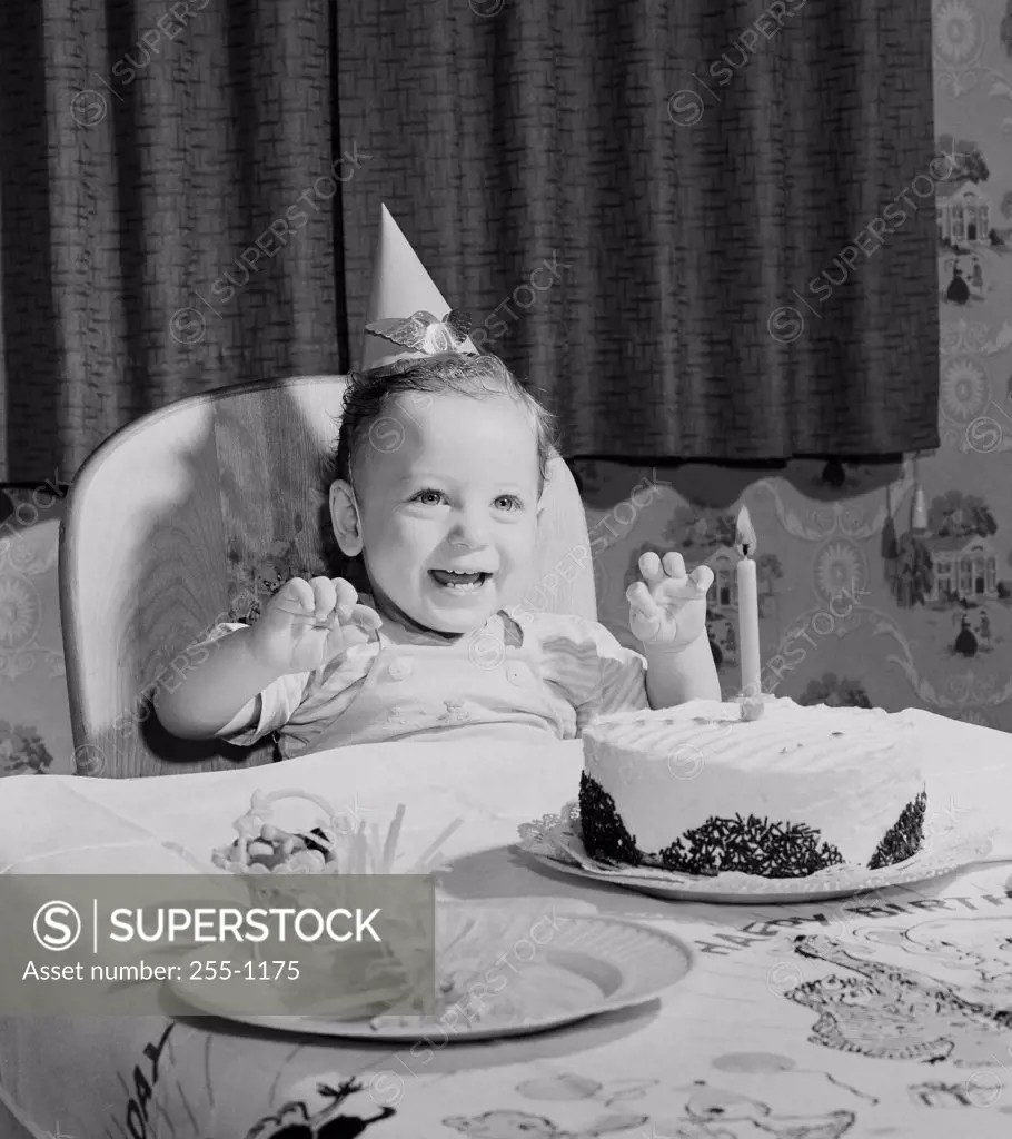 Boy sitting at table with birthday cake