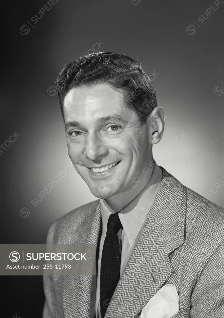 Vintage Photograph. Happy brunette man wearing blazer and tie smiling