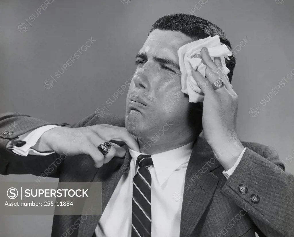 Close-up of a businessman wiping his face with a handkerchief
