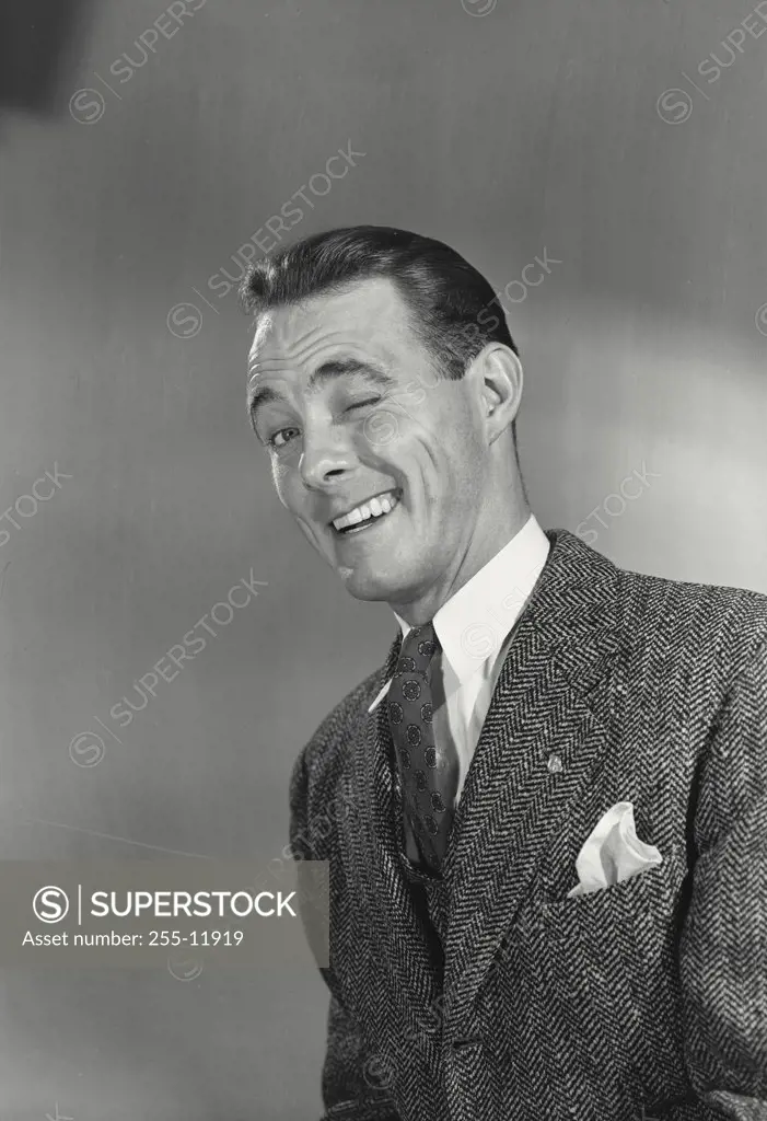 Close-up of a businessman winking and smiling