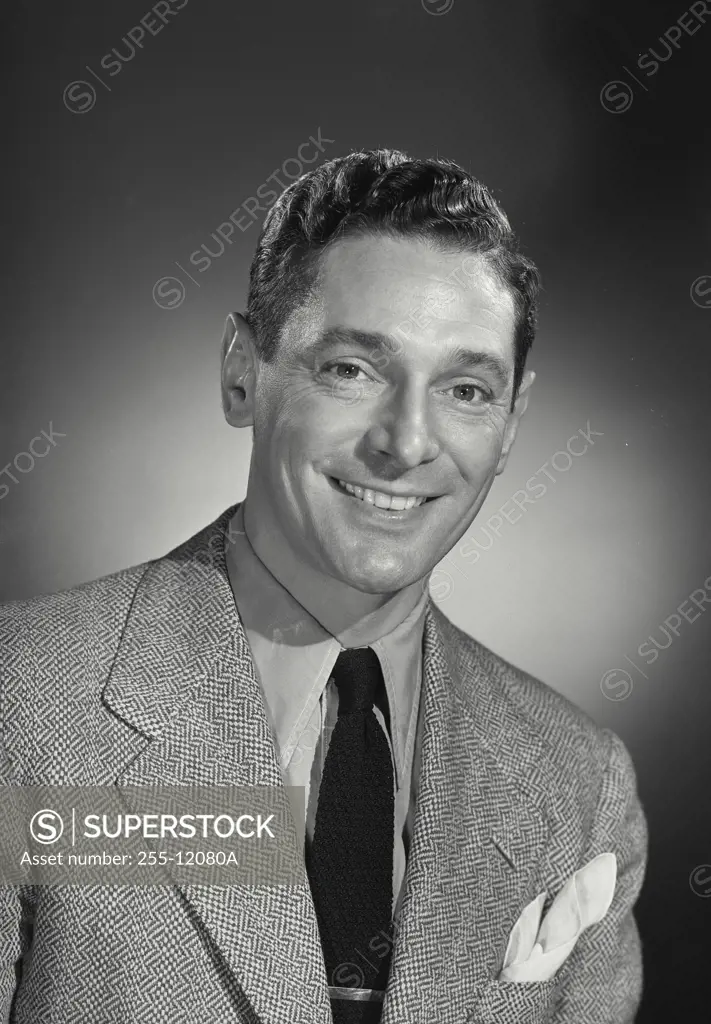 Vintage Photograph. Man with dark hair wearing blazer and tie with nice smile