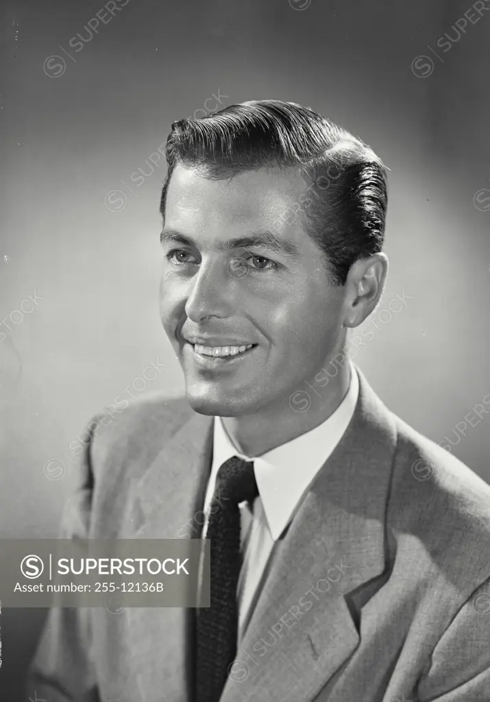 Vintage photograph. Portrait of Man in suit and tie smiling off camera