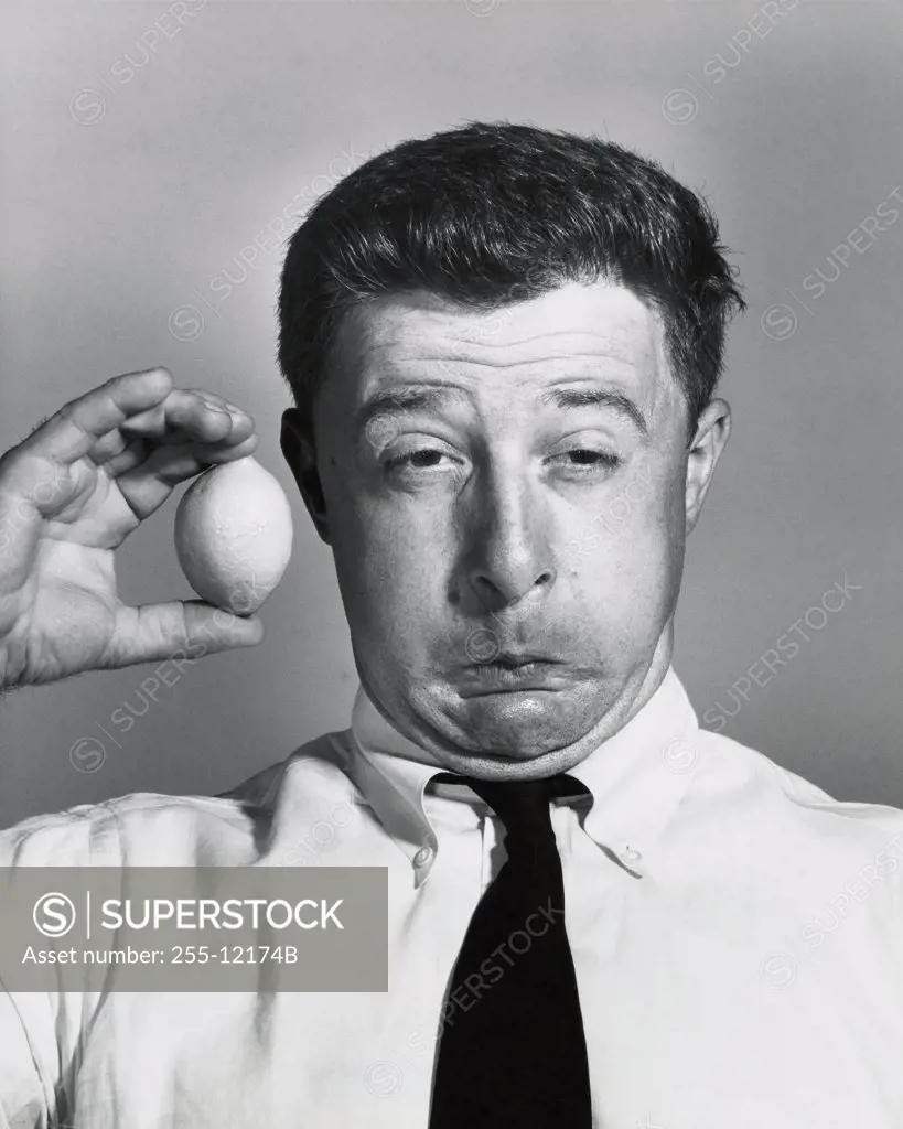 Close-up of a businessman holding a lemon and making a funny face