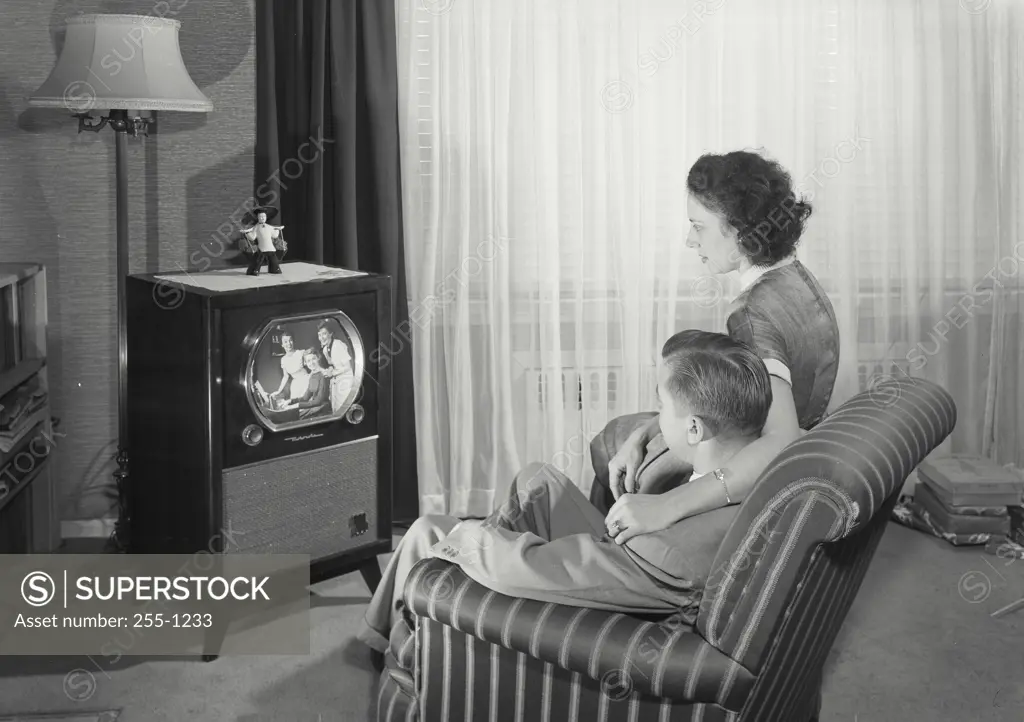 Vintage Photograph. Man and Wife sitting in chair wtching television