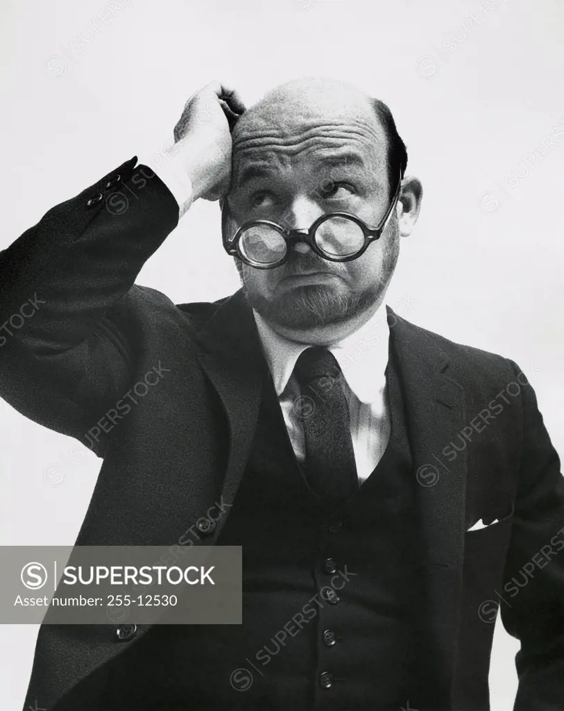 Close-up of a businessman scratching his head and thinking