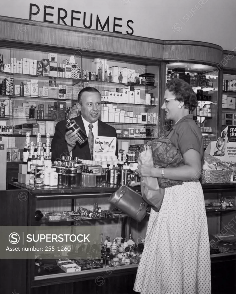 Salesman showing a perfume bottle to a customer