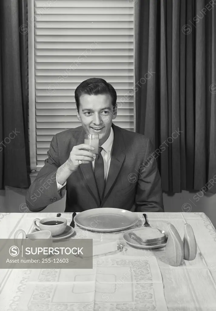 Vintage Photograph. Man at table drinking juice.