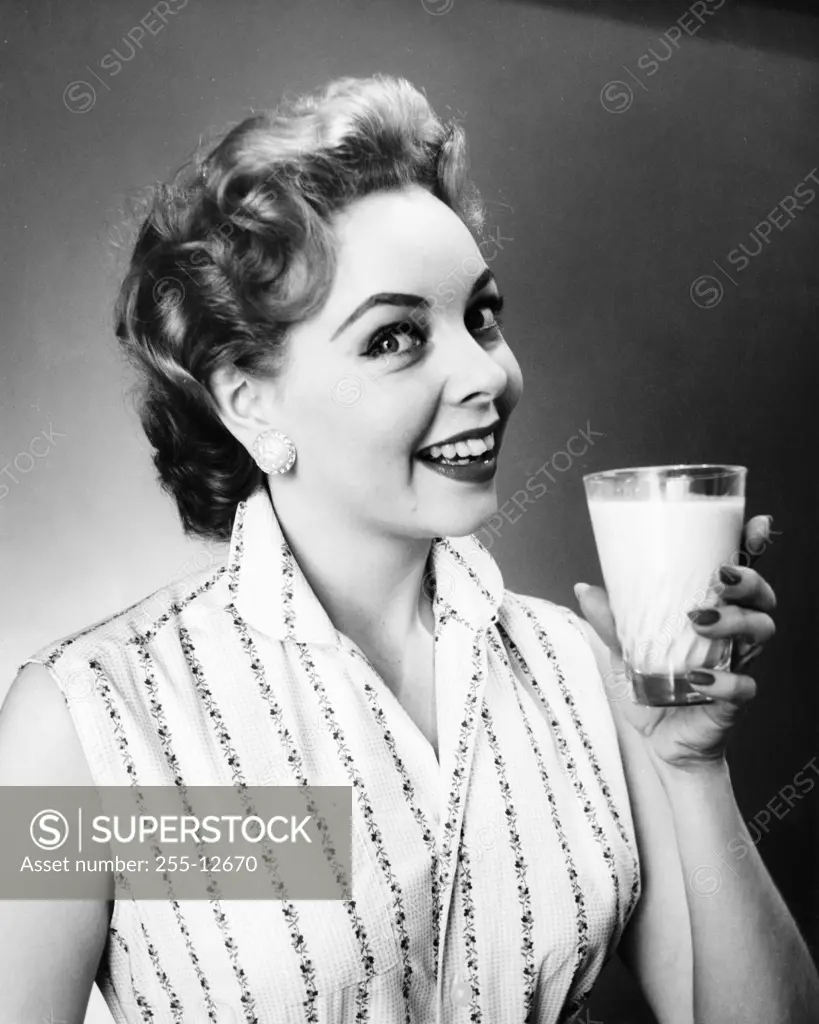 Portrait of a young woman holding a glass of milk