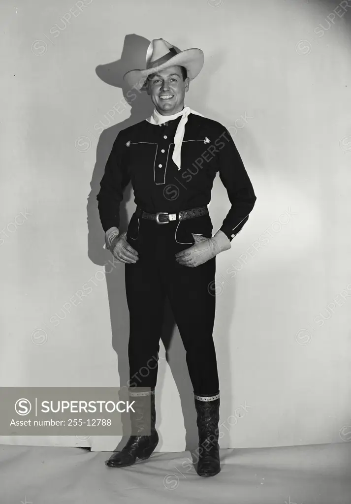 Vintage Photograph. Smiling man in black cowboy outfit with cowboy hat and white bandana