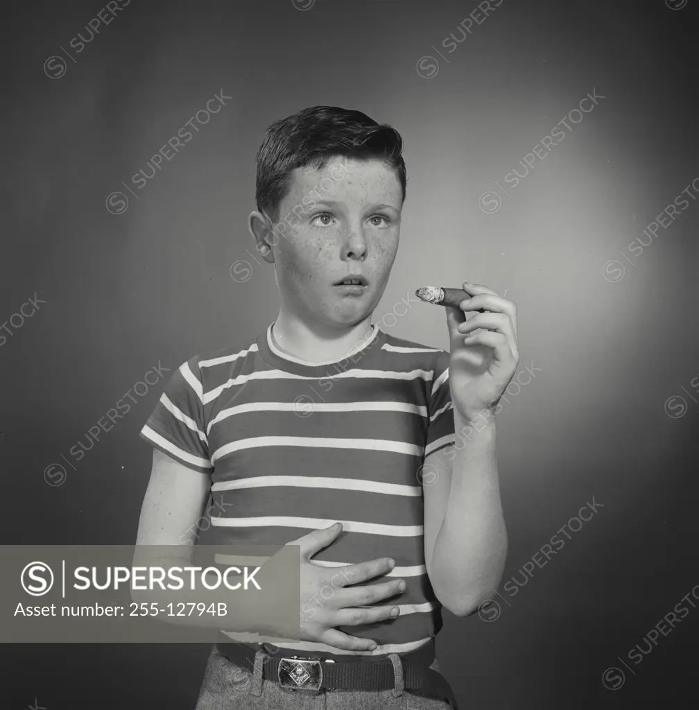 Vintage Photograph. Boy with upset stomach holding large cigar. Frame 2